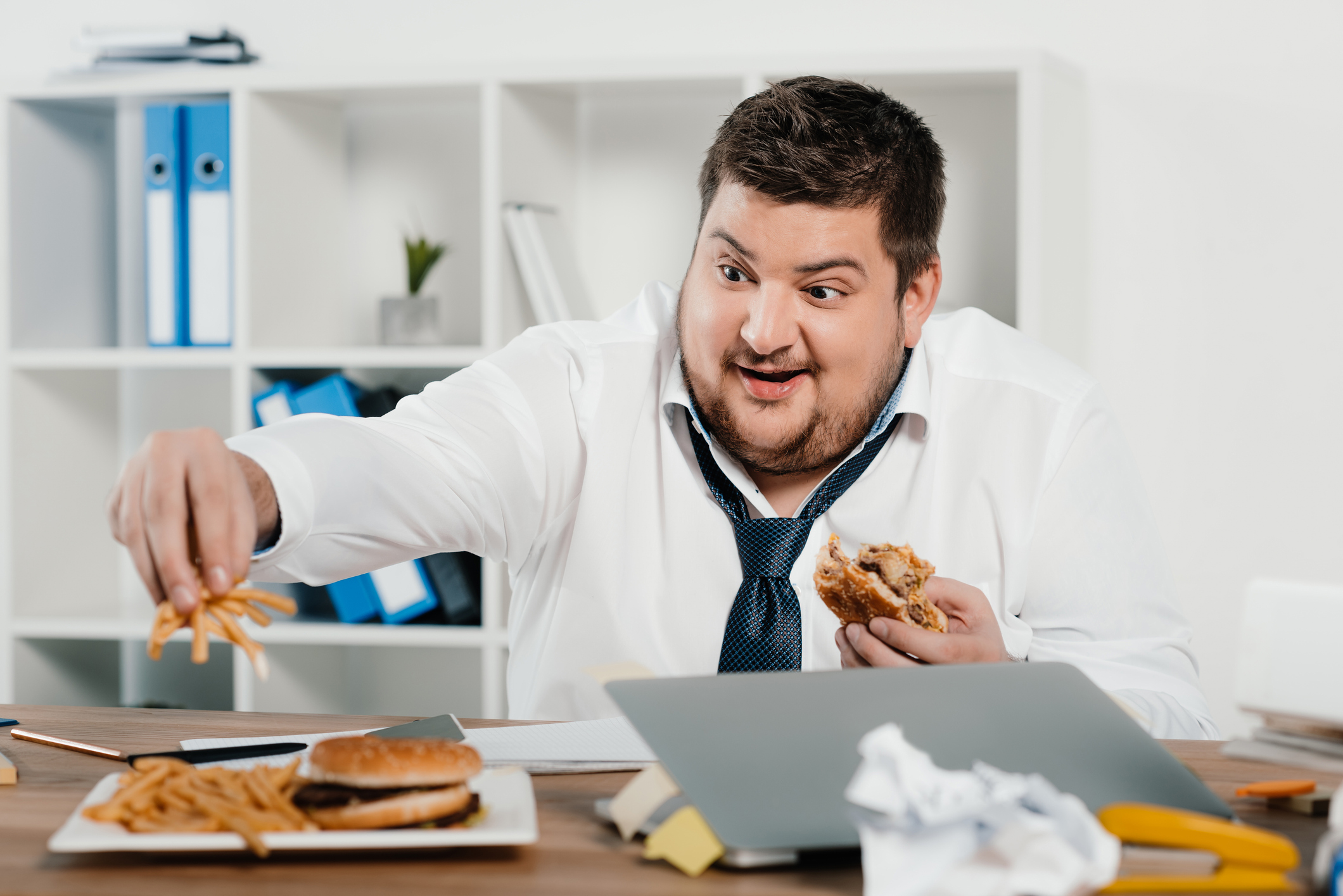 Obese office worker eating on the job